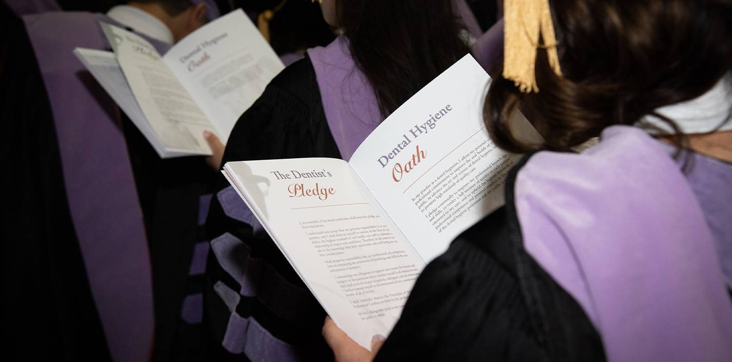 Over-the-should view of UTHealth Houston's School of Dentistry commencement program showing The Dentist’s Pledge and the Dental Hygiene Oath.