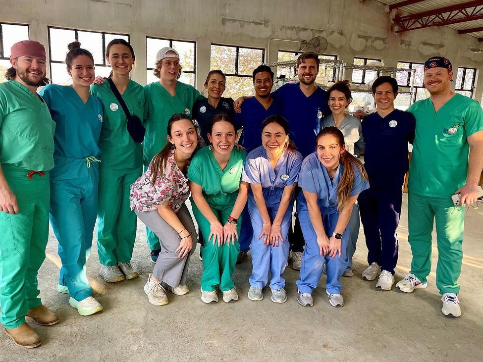 Group of dental students pose for a photo in their scrubs