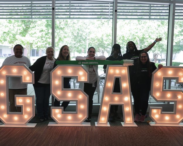 Group photo behind large event signage letters.