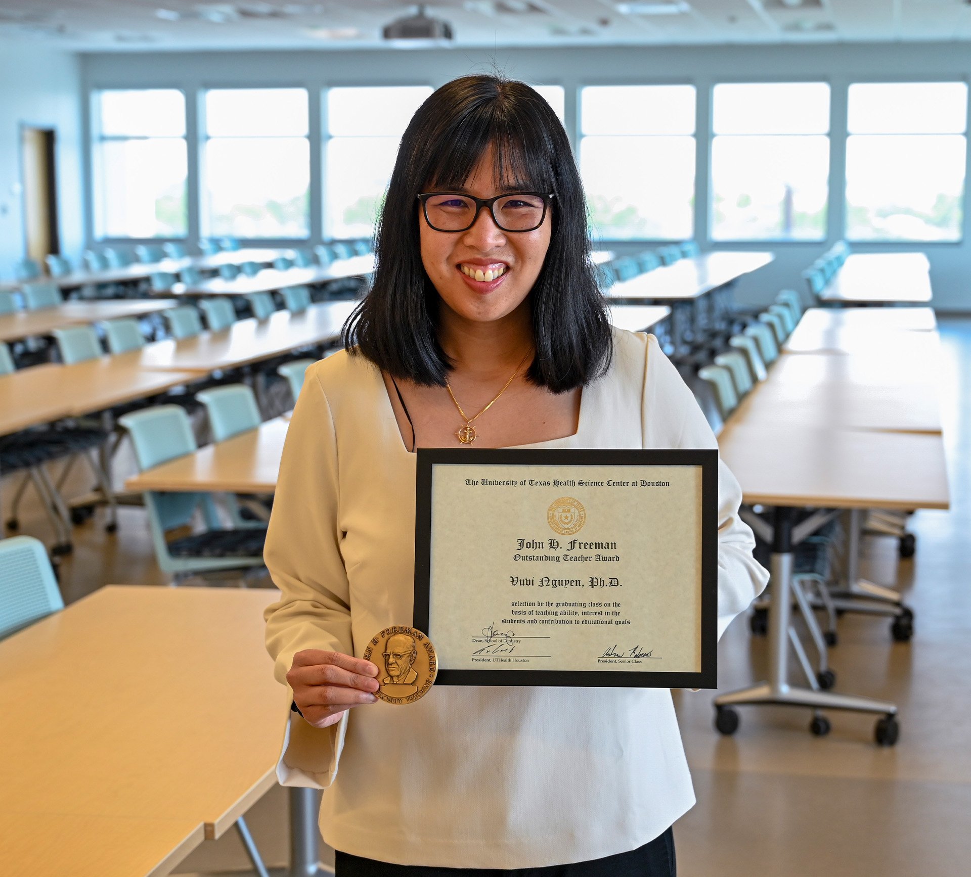 Dr. Vuvi Nguyen with her framed certificate for the John H. Freeman Award for Faculty Teaching.