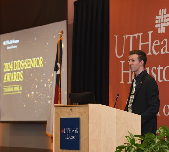 Dental Class of 2024 Vice President Van DeMille speaks at the podium during the 2024 DDS Senior Awards.