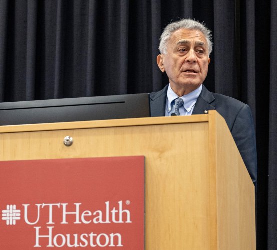 Man gives a presentation behind a podium.