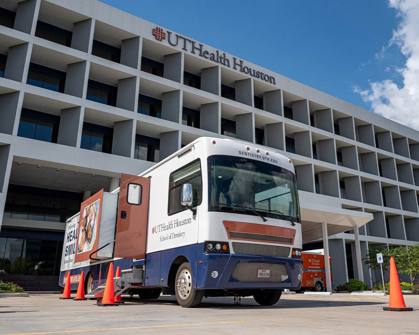 Mobile dental van parked outside of building.