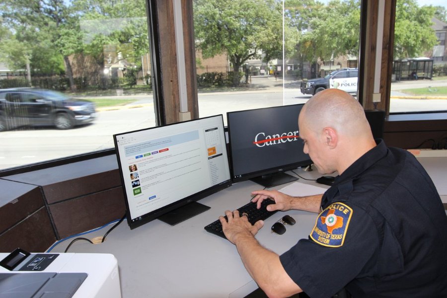 A UTPD officer works at a computer in the new guardhouse, with a wide view of Cambridge Street.