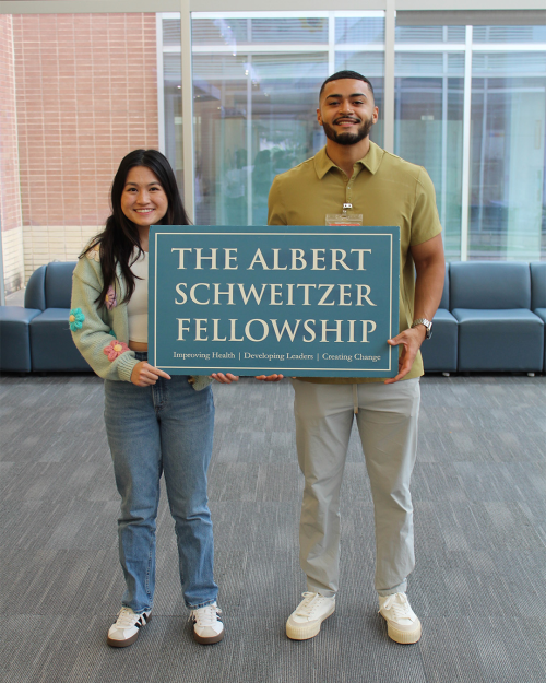 Two people co-holding a sign.