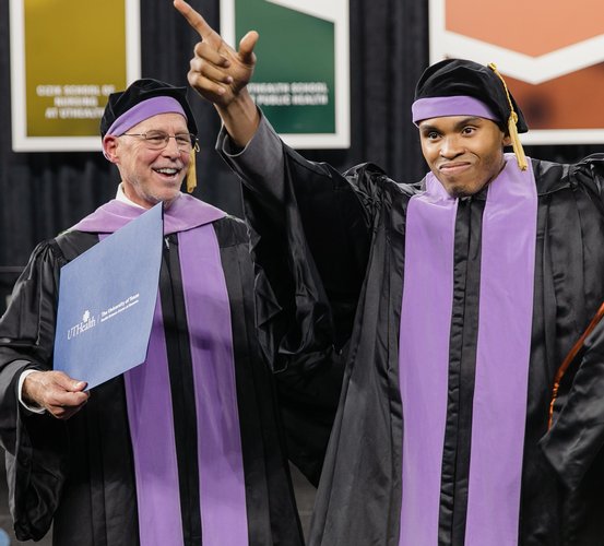 Ikechukwu T. Osemene, DDS ’21 (right), celebrates with Assistant Dean for Admissions and Student Services Ralph A. Cooley, DDS, as he walks across the stage at UTHealth School of Dentistry’s 116th commencement ceremony.