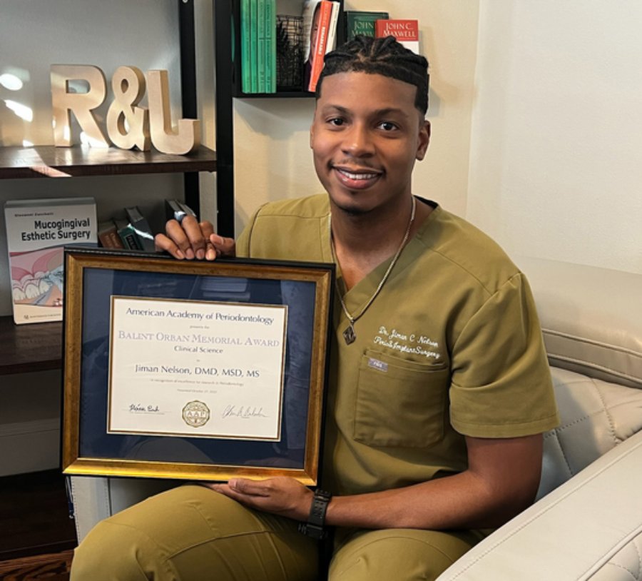 Jiman Nelson, DMD, MDS, MS ’22, sits with his 2022 Balint Orban Memorial Competition plaque.