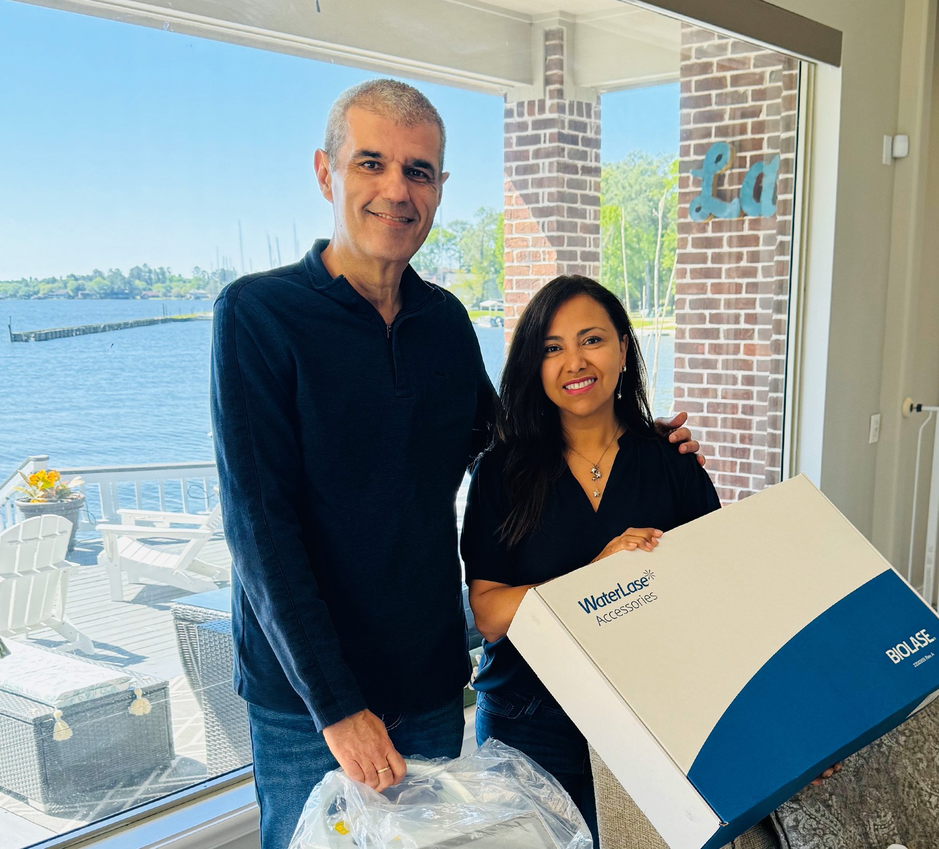 Dr. Lillian Lyons (right) and with Dr. Nikola Angelov, chair of the Department of Periodontics and Dental Hygiene, with the donated BIOLASE Waterlase iPlus laser unit.