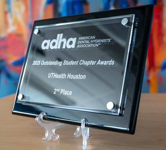 Close-up of the 2025 Outstanding Student Chapter Award second-place plaque from the American Dental Hygienists’ Association, a black plaque with the AHDA logo and award details in white lettering.