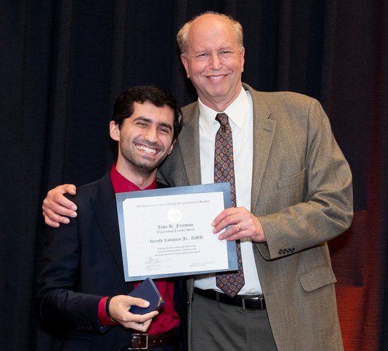 Dr. Harold Kolodney Jr. (right) accepts his John H. Freeman Award for Faculty Teaching during the 2022 DDS Senior Awards from Student Council President Ali Al Hatem.