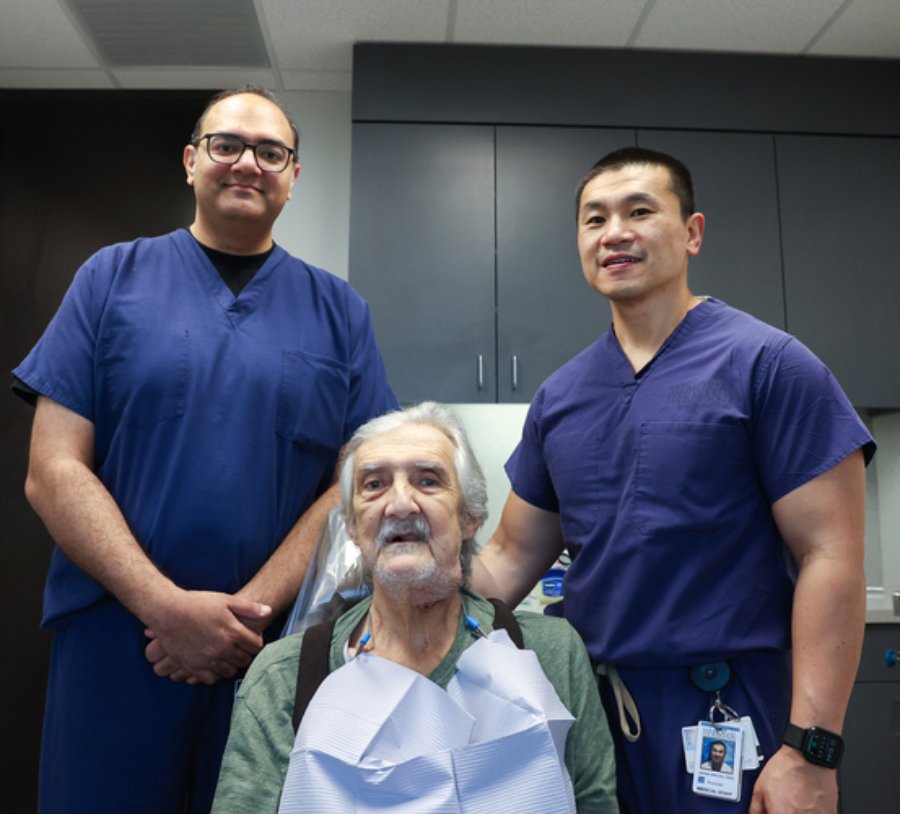 Patient William Baker (center) sits at his August post-operative appointment with James Melville, DDS (right); and resident Omar Ahmed, DDS.