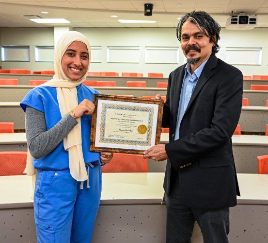 Dental student Hanan Abdegilil (left) holds her Most Outstanding Presentation in Basic Science Research Award from the 28th Annual Hinman Student Research Symposium alongside her faculty mentor, Dr. Ransome van der Hoeven.