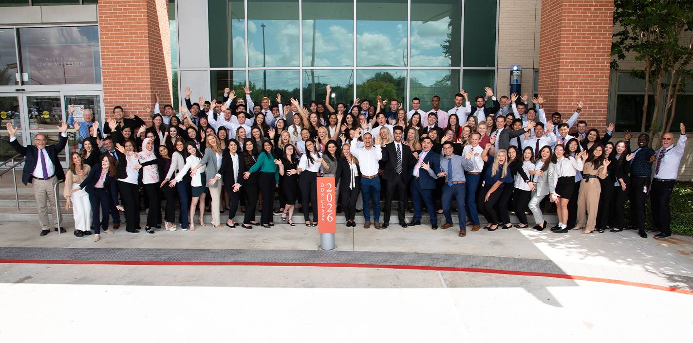 Members of the Dental Class of 2026 gather for a group photo on the front steps of UTHealth Houston School of Dentistry. Photo by Brian Schnupp.