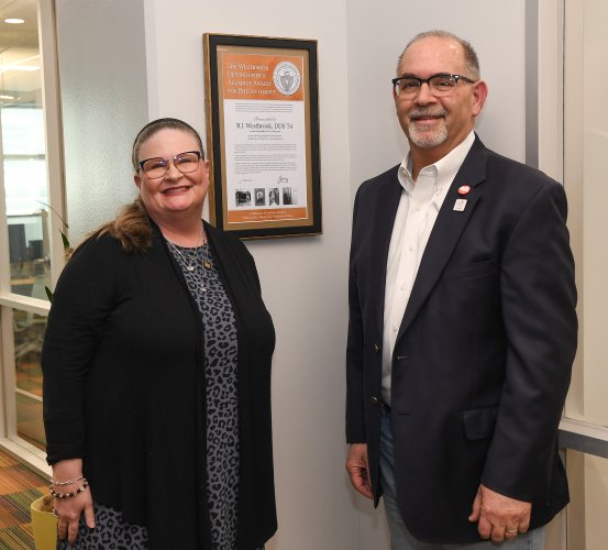 Library & Learning Commons Director Janet Fenske (left) and Dean John A. Valenza, DDS, next to a commemorative certificate that honors B.J. Westbrook, DDS.