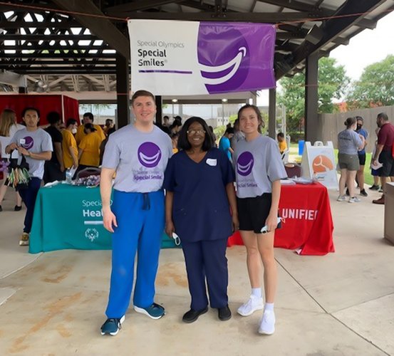 Dental students Andre Larue (left) and Camille Hoover (right) with Dr. Esther Kuyinu at the 2022 Special Olympics Texas Summer Games in San Antonio.