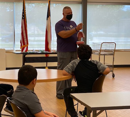 Dental van driver Pat Henshaw, RDA, CDA, teaches oral hygiene to a group of boys at a Houston-area YMCA.