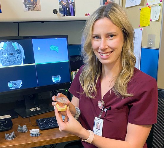 Dr. Chelsea Wehr holds a 3D-printed corrective appliance for cleft lip and palate.