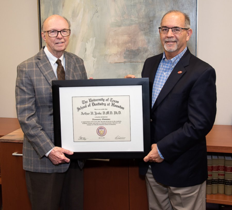 Arthur Jeske, DMD, PhD (left), holds his Honorary Alumnus Award with Dean John Valenza, DDS.