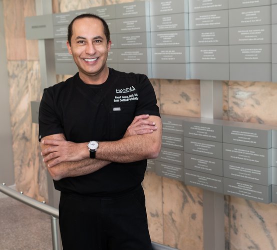 Raouf J. Hanna, DDS, poses in front of the donor wall at UTHealth Houston School of Dentistry.