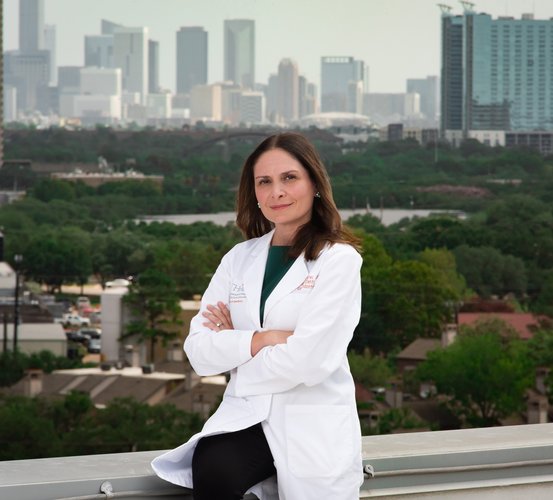 Dr. Shalizeh “Shelly” Patel sits on the roof railing of UTHealth Houston School of Dentistry