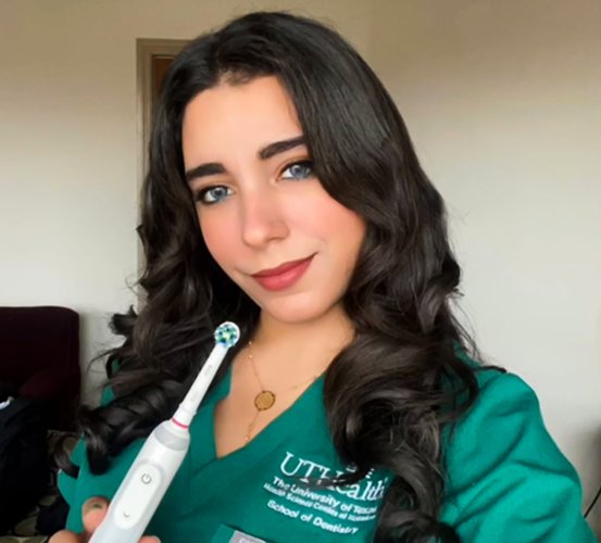 Reham Abuabeileh, Dental Hygiene Class of 2022 President, holds a tooth brush as part of Daily 4 video.