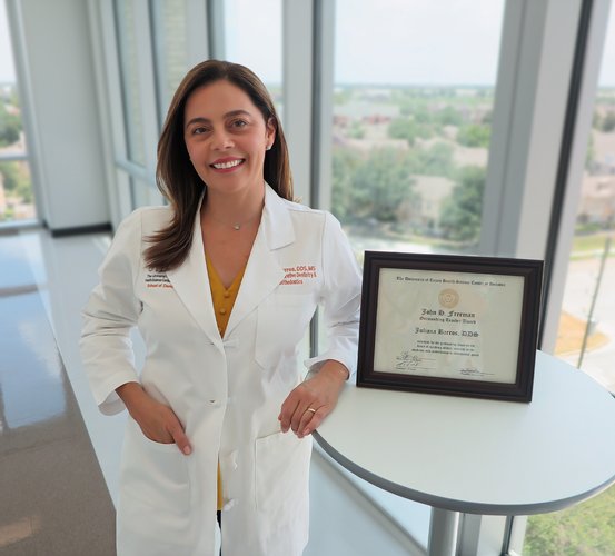 Dr. Juliana Barros with her framed certificate for the John H. Freeman Award for Faculty Teaching.