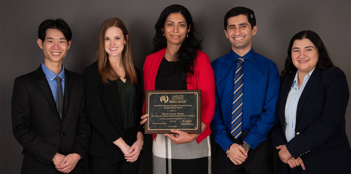 Dr. Dharini van der Hoeven (center) holds her National Student Research Group Mentor of the Year plaque, while flanked by officers from the UTHealth Houston School of Dentistry Student Research Group.