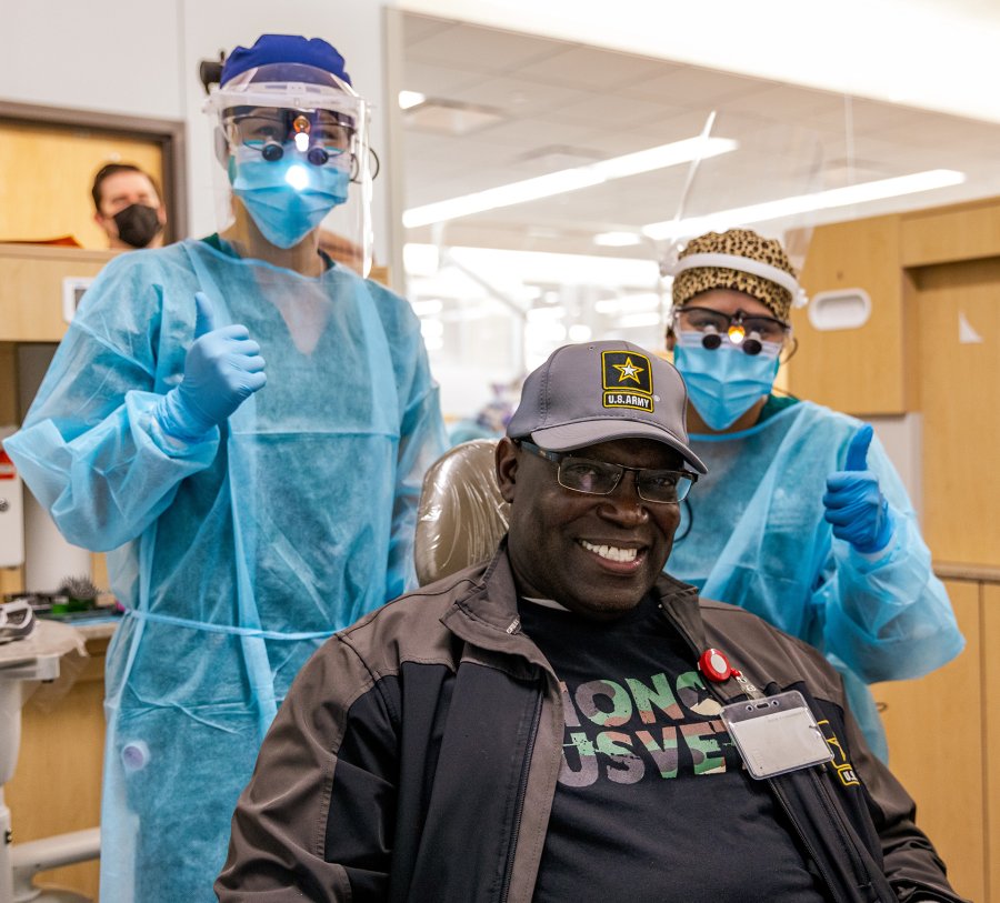 U.S. Army veteran Danny Sneed (center) is all smiles after completing his cleaning with dental hygiene students at the 7th Annual Give Vets A Smile at UTHealth Houston School of Dentistry.