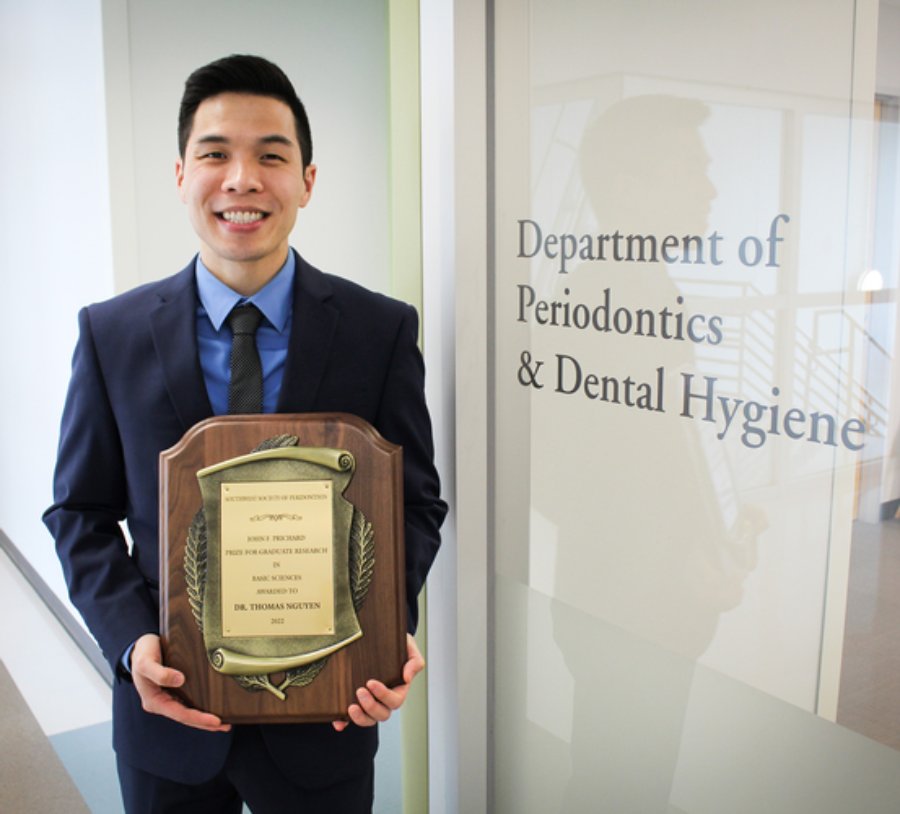 Dr. Thomas Nguyen stands with his John F. Prichard Graduate Research Competition plaque on April 26, 2022.