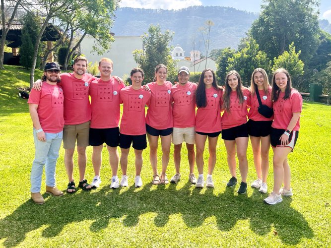 Dental students pose in front of the Guatemalan countryside.