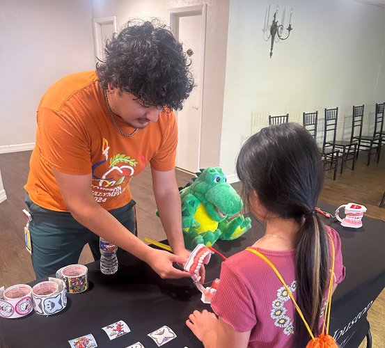 Hygiene student showing toothbrushing technique on model.