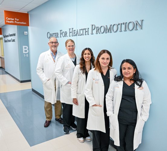 Faculty and leadership associate with the Center for Health Promotion stand for a group photo under the clinic’s name.