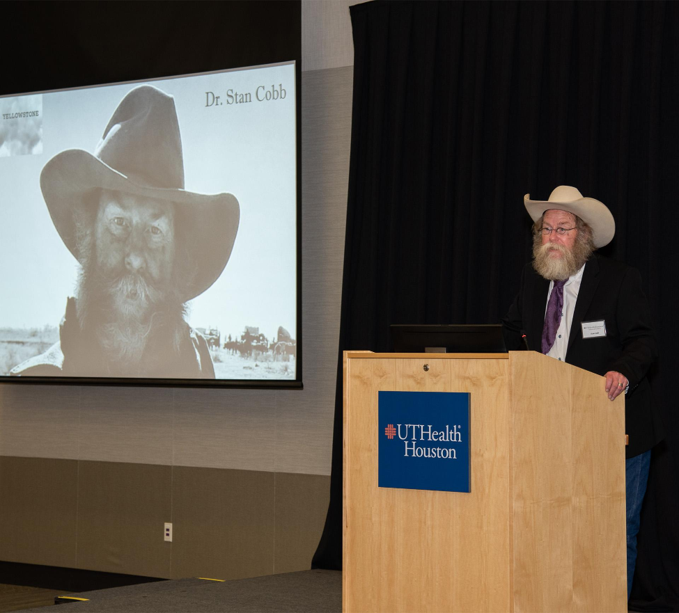 Keynote speaker Stan Cobb, DDS, address guests as an image of himself on the set of Paramount+'s 