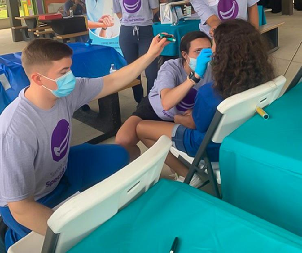 Dental students Andre Larue (left) and Camille Hoover screening a Special Olympics athlete.