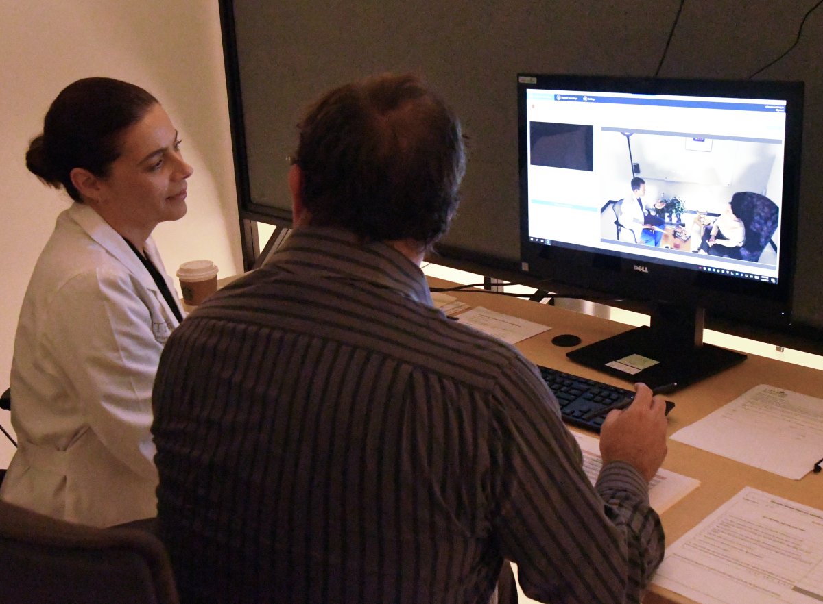 Drs. Juliana Barros and Hal Halpin watch as a dental student visits “Carol,” a standardized patient. Drs. Juliana Barros and Hal Halpin watch as a dental student visits “Carol,” a standardized patient.