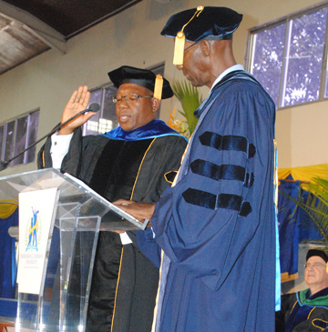 Dr. Lincoln Edwards in graduation regalia, right hand raised to swear an oath. Dr. Lincoln Edwards in graduation regalia, right hand raised to swear an oath.