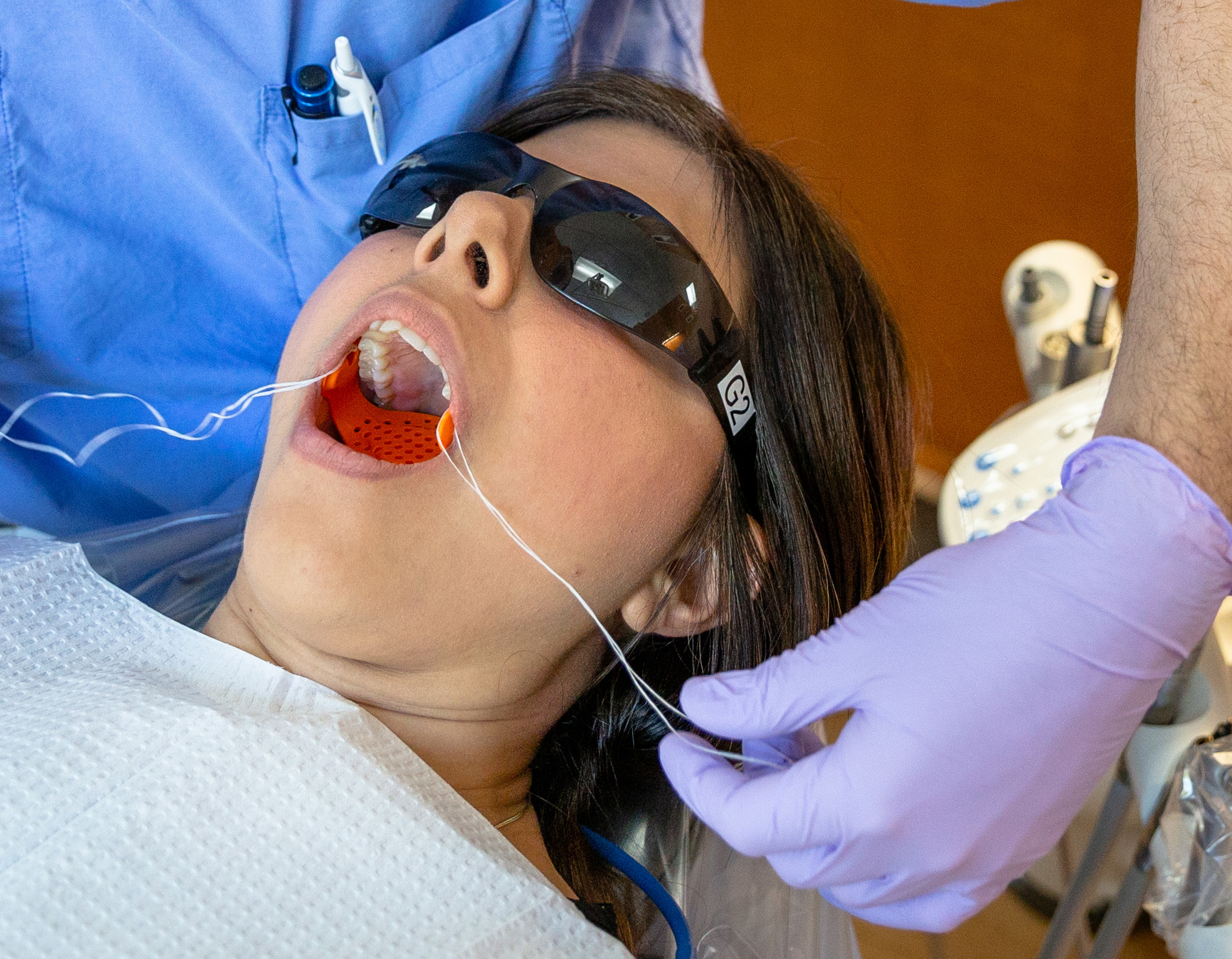 A female dental patient with mouth open to show Airway Armor™ in place, with floss hanging from holes in the side of the device. A female dental patient with mouth open to show Airway Armor™ in place, with floss hanging from holes in the side of the device.