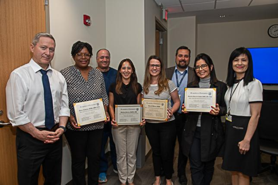 Group photo of people holing up certificates of completion.