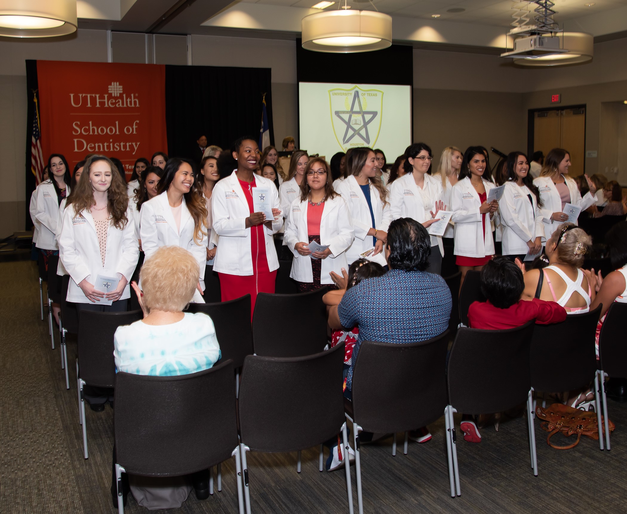 New dental hygiene students turn to face the audience. New dental hygiene students turn to face the audience.