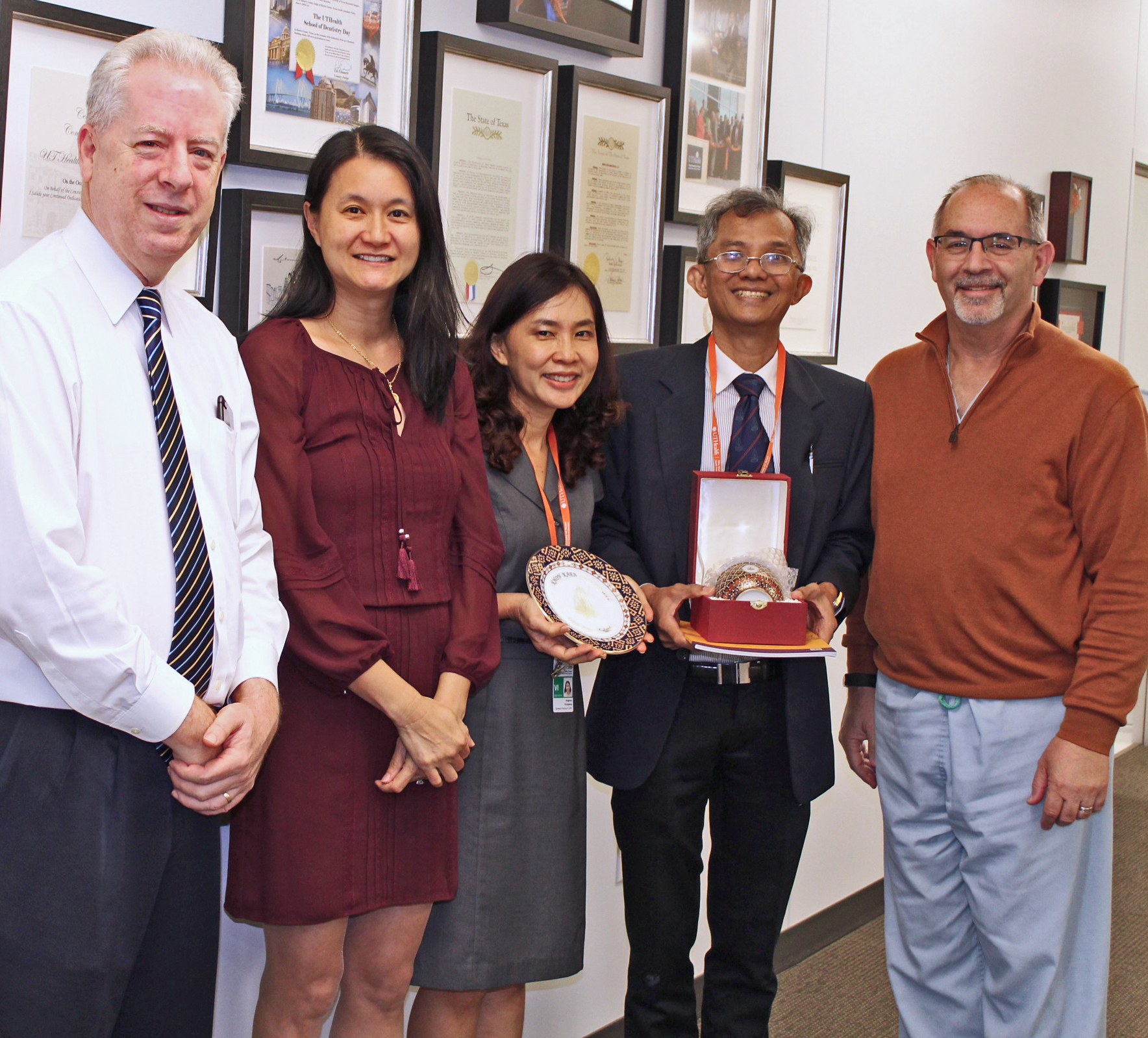 Drs. Angkana Klungtong and Danai Yodsuwan of Khon Kaen University (with gifts). From left are Drs. Robert Spears, Sudarat Kiat-amnuay, Klungtong, Yodsuwan, and John Valenza, dean. Drs. Angkana Klungtong and Danai Yodsuwan of Khon Kaen University (with gifts). From left are Drs. Robert Spears, Sudarat Kiat-amnuay, Klungtong, Yodsuwan, and John Valenza, dean.