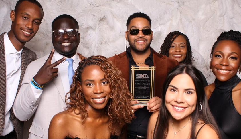 Students pose for a group photo in a photobooth.