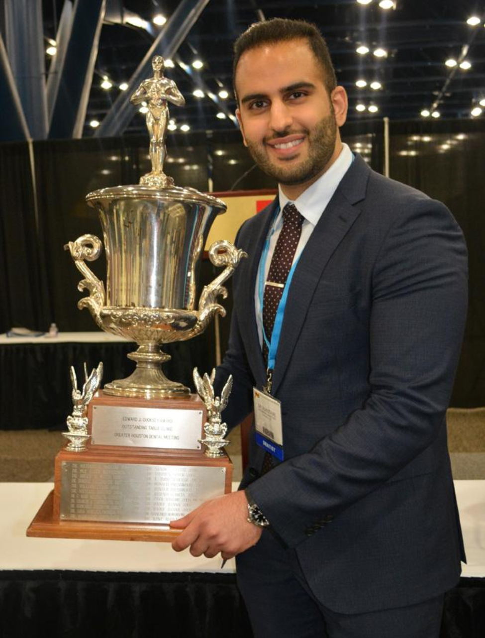 Dr. Mohammad Almutairi, a UTHealth Houston prosthodontics resident,  holds the trophy for winning the 2019 Edward J. Cooksey Award.