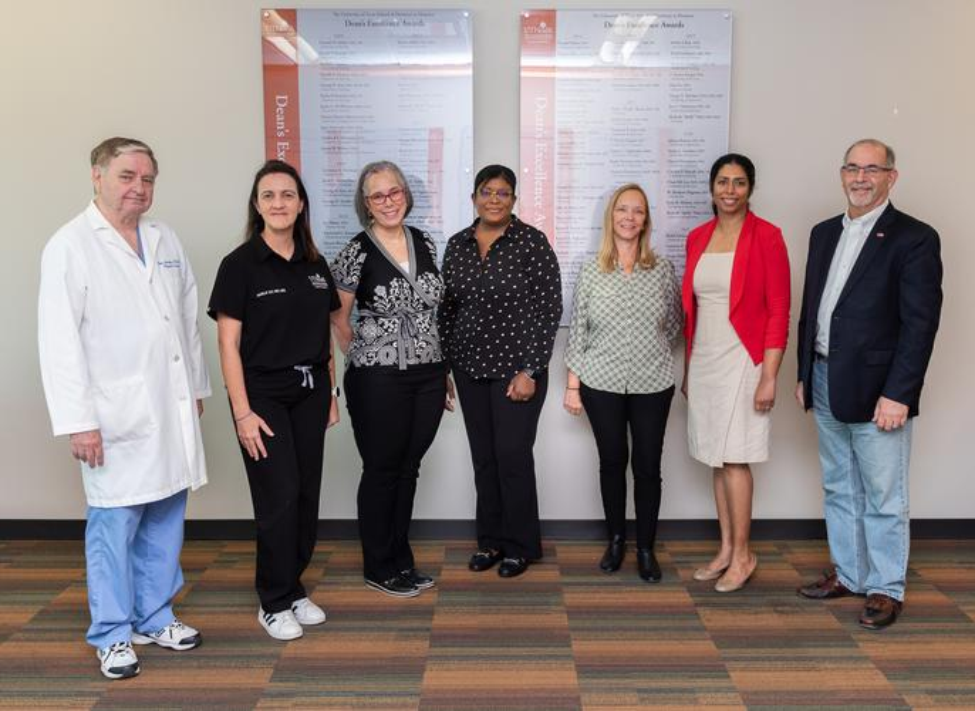 2022 Dean’s Excellence Awards recipients (from left): Drs. Charles Streckfus, Marilia Sly, Joann Marruffo, Marie Latortue, Dianna Arriaga, and Dharini van der Hoeven stand with Dean John A. Valenza, DDS. Not pictured: Drs. Gargi Mukherji and Simon Young.