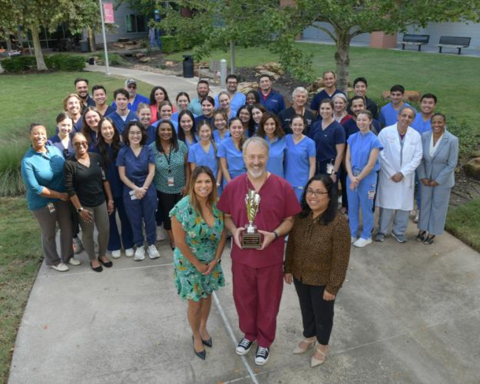 A group of dental professionals pose with a trophy.