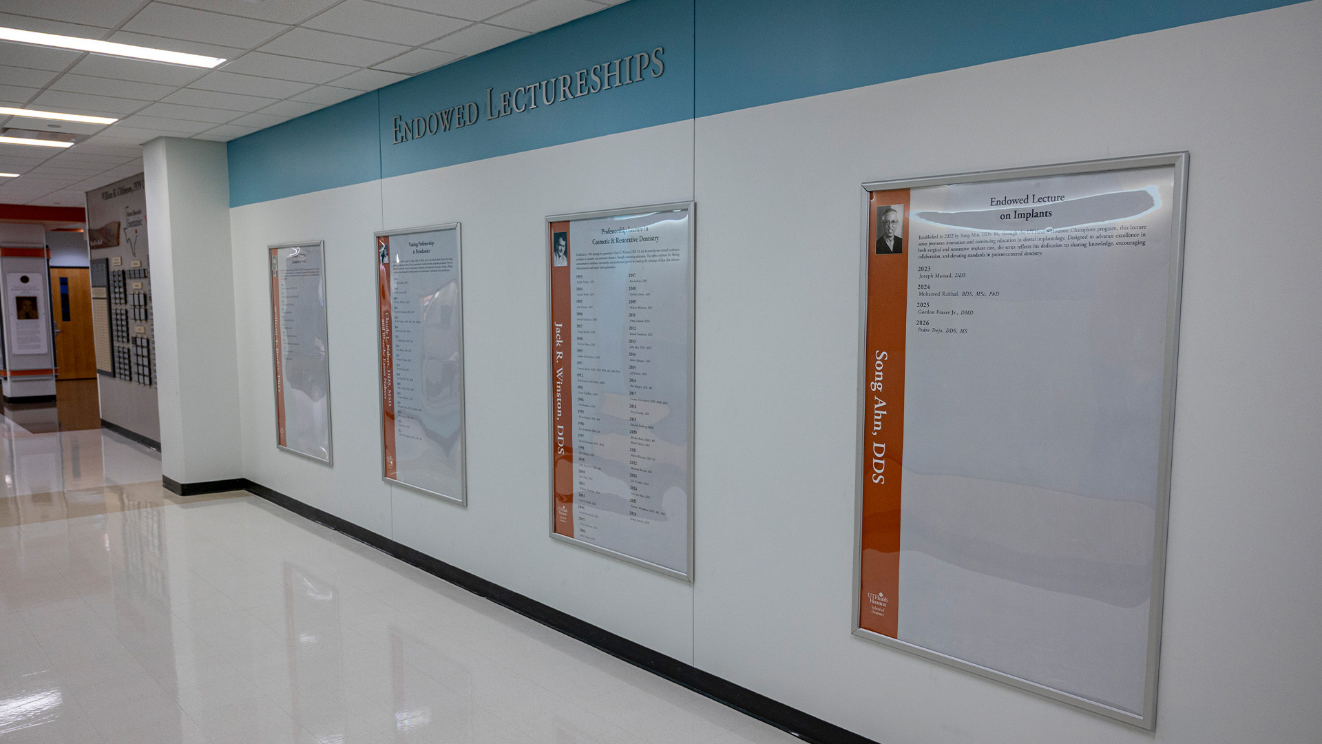 A hallway display titled Endowed Lectureships features multiple framed posters mounted on a white wall with a blue header, each highlighting a different named lectureship.